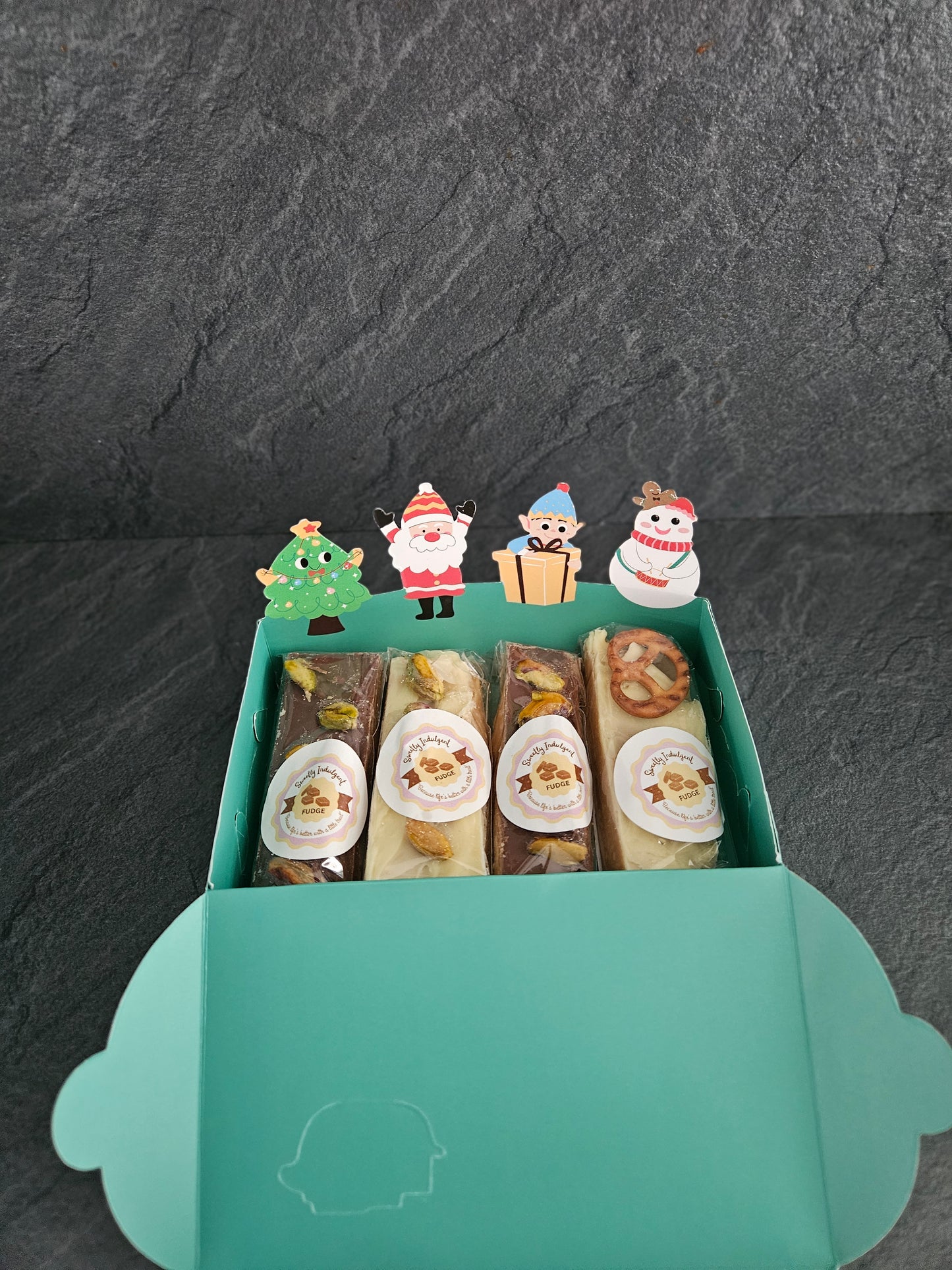 Green Box of assorted fudge bars with decorative packaging on a dark surface