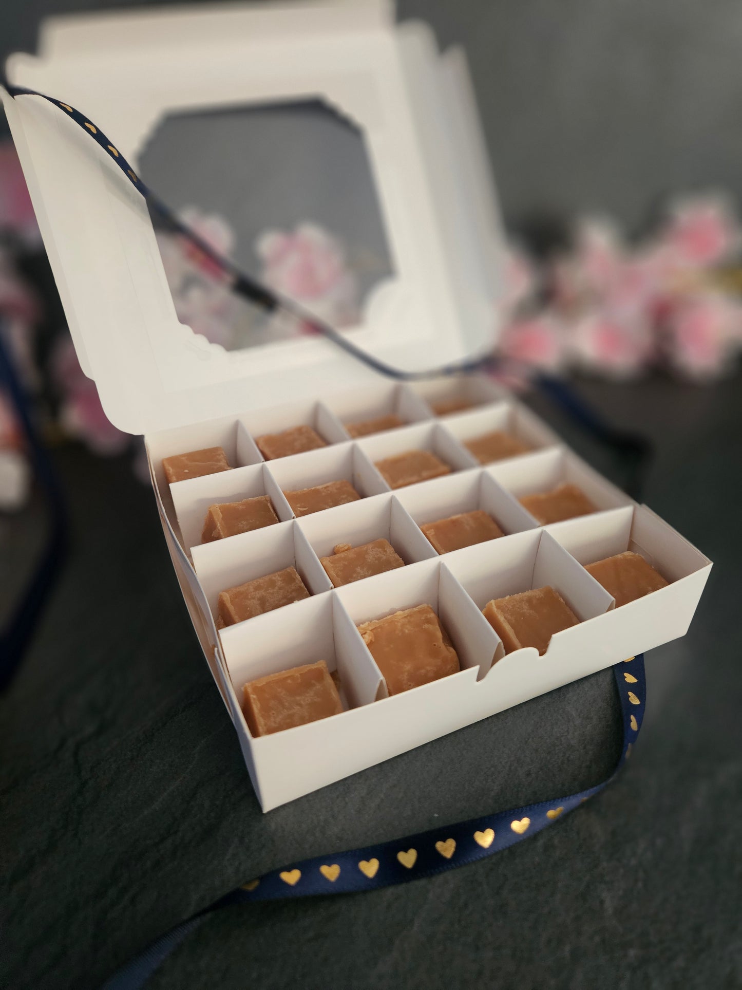 Large gift box open showing fudge chunks with floral background