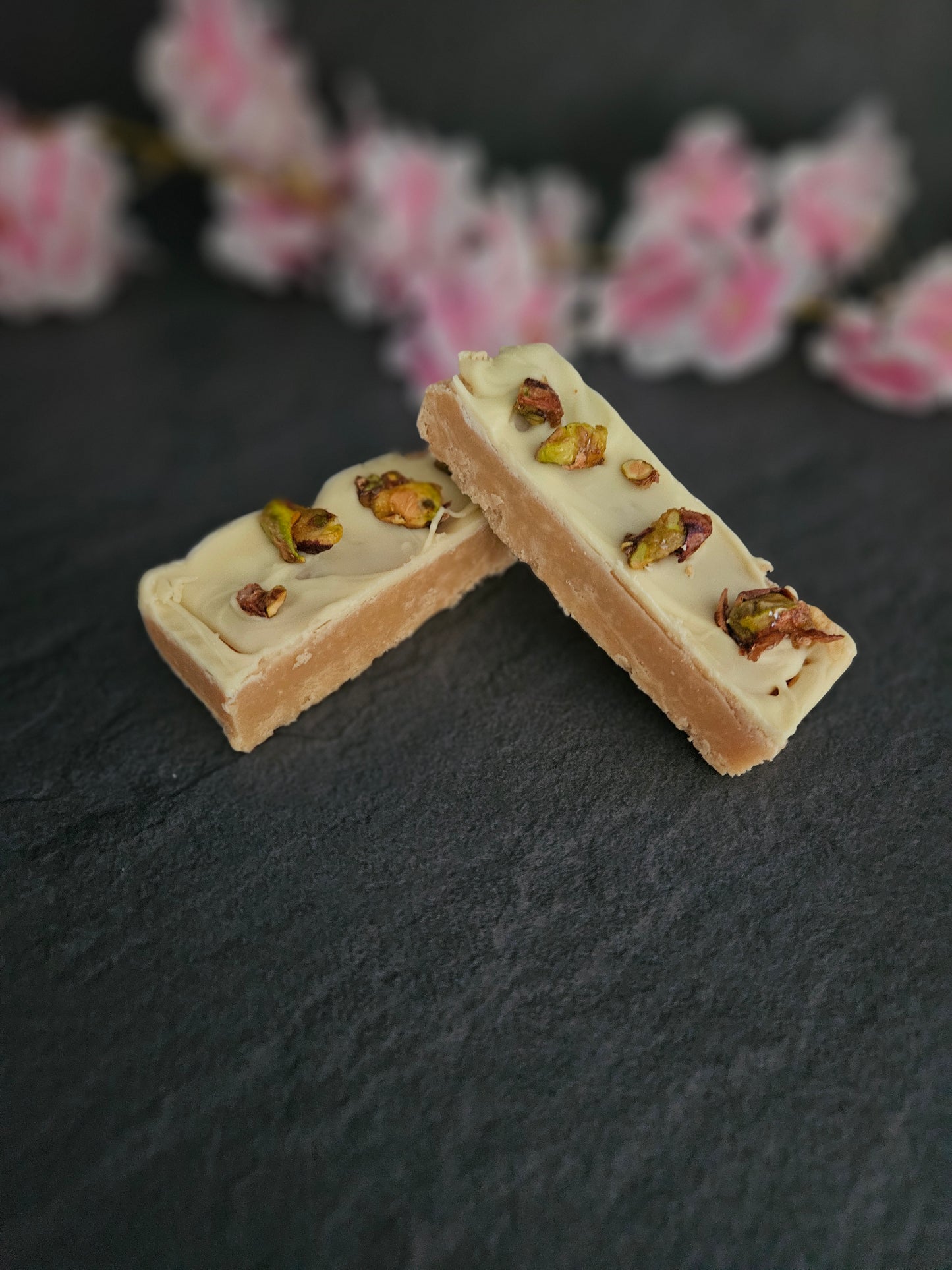 2 x White chocolate and pistachio fudge bars laid on top of each other with grey background