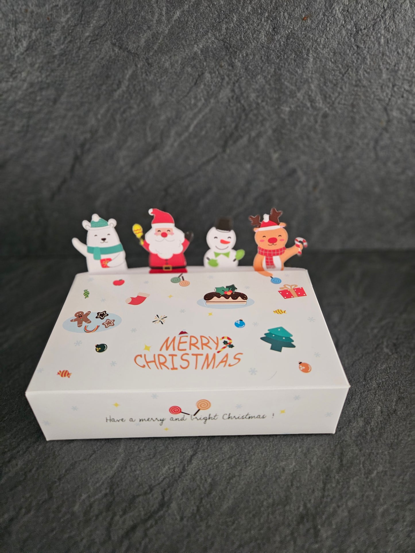 White Christmas-themed box with cartoon characters on a dark gray background