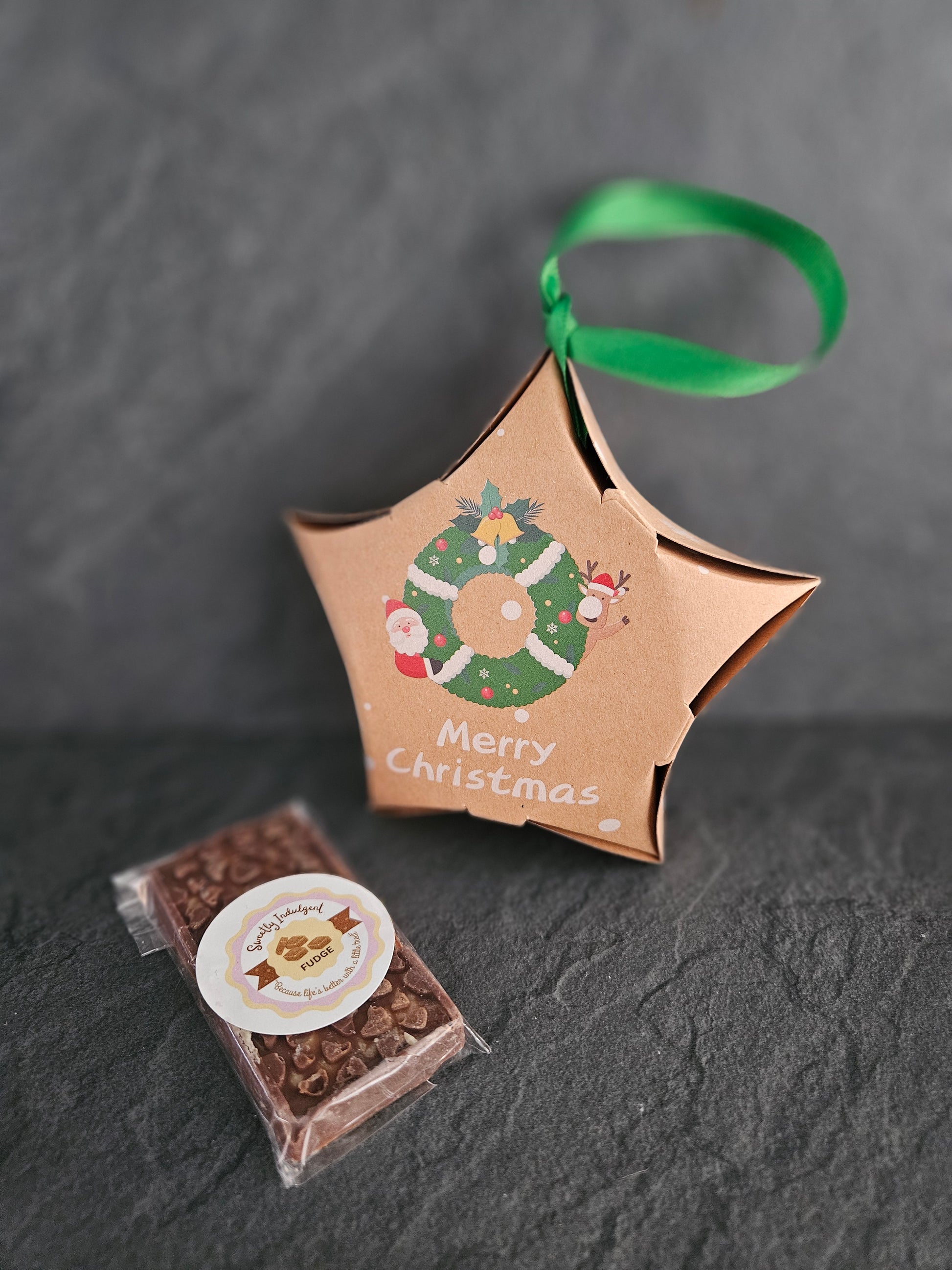 Christmas star packing with milk chocolate fudge bar on a grey surface