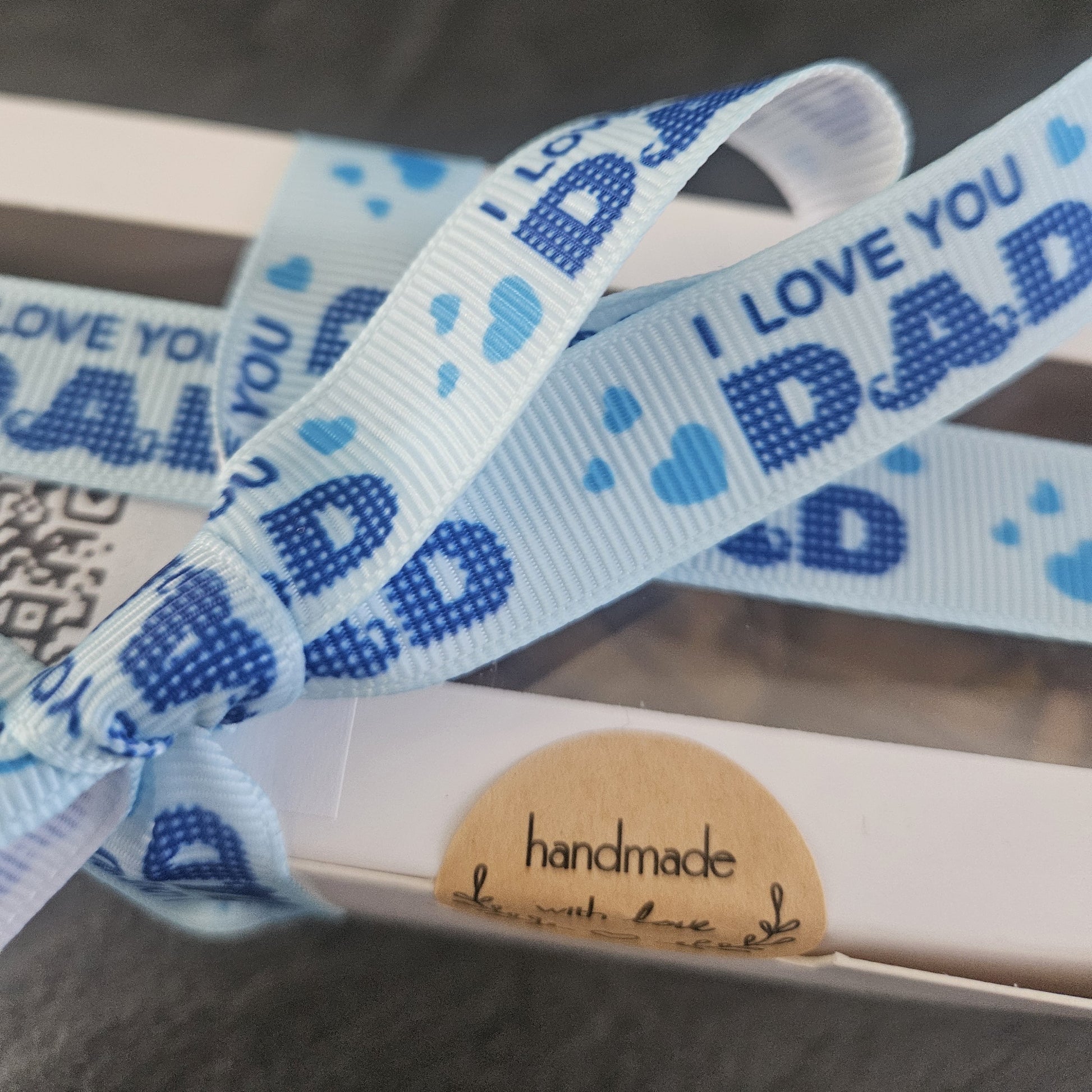 Blue and white ribbon with 'I Love You Dad' text on a white box.