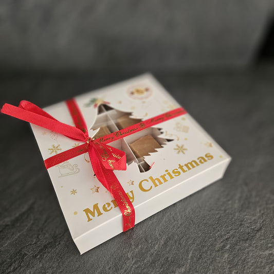 Christmas-themed fudge gift box with a red ribbon on a dark surface
