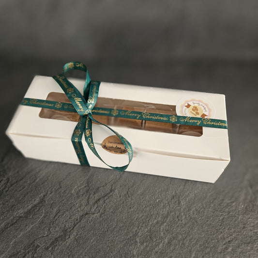 Christmas fudge gift box with 8 fudge pieces and a green ribbon on a dark grey background