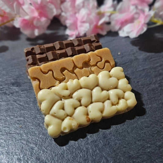 3 Assorted snack size small fudge bars on grey background, white chocolate, milk chocolate and plain fudge