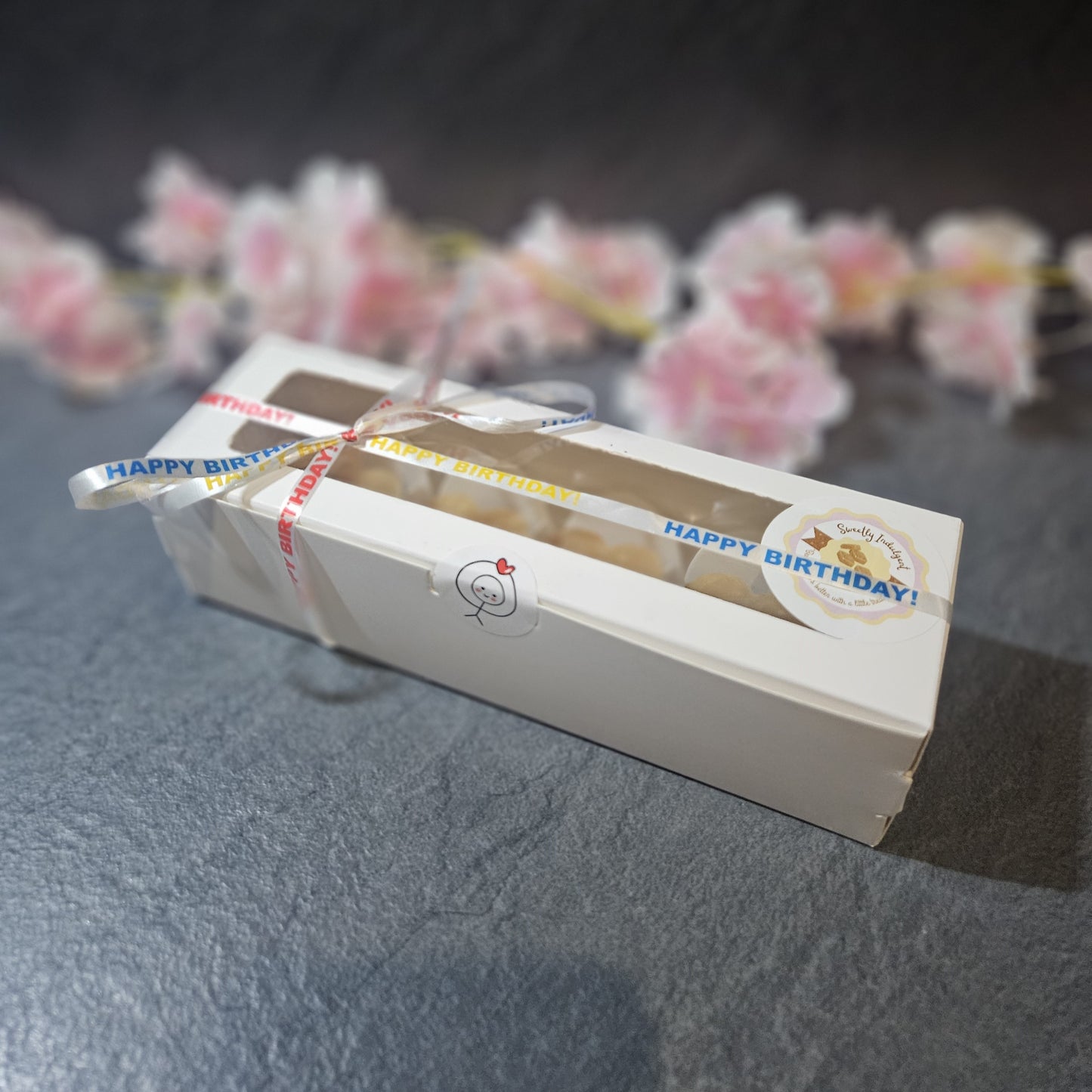 Box of birthday fudge with 'Happy Birthday' labels on a grey surface